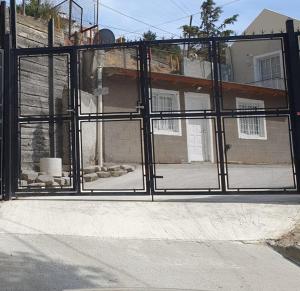 a gate in front of a house with a building at Alojamiento Chamigo in Comodoro Rivadavia