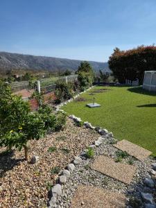 a garden with rocks and a yard with a lawn at Casa 3 quartos - Outeiro do Sul in Adopisco