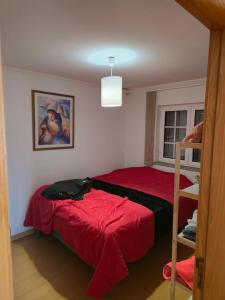 a bedroom with a bed with a red bedspread at Casa 3 quartos - Outeiro do Sul in Adopisco