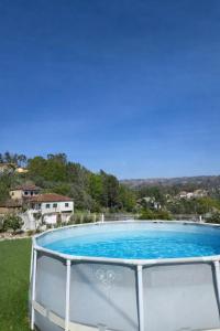 a large blue swimming pool in a yard at Casa 3 quartos - Outeiro do Sul in Adopisco