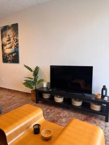 a living room with a flat screen tv on a wall at Seashore Happiness Apartments in Porto Rafti +36 photos