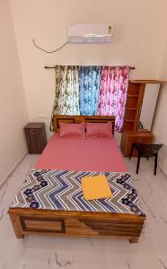 a bedroom with a bed with a red bedspread at Star Varkala Homestay in Varkala +6 photos