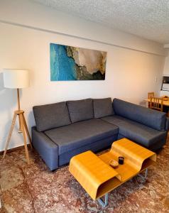 a living room with a couch and a table at Seashore Happiness Apartments in Porto Rafti
