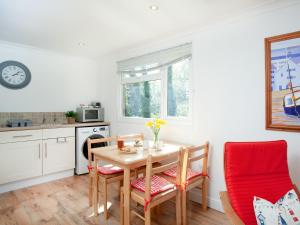 a kitchen with a table and two chairs and a kitchen with white cabinets at Lodge 133 - Uk43196 in Saint Merryn