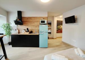 a kitchen with a blue refrigerator and a microwave at Elite Muralla Lugo Experience 2.1 in Lugo