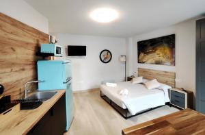 a room with a bed and a kitchen with a sink at Elite Muralla Lugo Experience 2.1 in Lugo