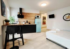 a kitchen with a refrigerator and a chair in a room at Elite Muralla Lugo Experience 2.1 in Lugo
