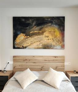 a painting hanging above a bed in a bedroom at Elite Muralla Lugo Experience 2.1 in Lugo +6 photos