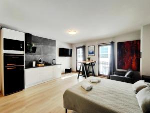 a living room with a bed and a kitchen at Suite imperial Muralla de Lugo 2.2 in Lugo