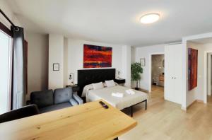 a living room with a bed and a couch at Suite imperial Muralla de Lugo 2.2 in Lugo