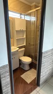 a small bathroom with a toilet and a shower at Residencial Las Palmeras in Iquique