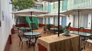 an empty patio with tables and chairs and umbrellas at Residencial Las Palmeras in Iquique