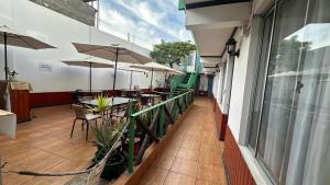 a balcony with tables and umbrellas on a building at Residencial Las Palmeras in Iquique