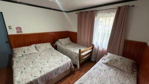 a bedroom with two beds and a window at Residencial Las Palmeras in Iquique +12 photos