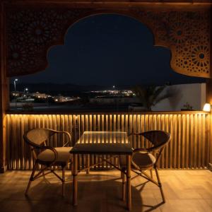 a table and chairs on a balcony at night at Zaytun Hotel Dahab in Dahab