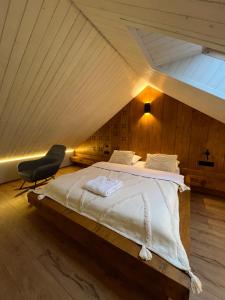 a bedroom with a large bed in a attic at Stodola Slavsko котедж з чаном-джакузі in Slavske +20 photos