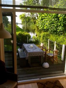 een tafel en stoelen op een terras met uitzicht op een rivier bij Sonnehûs in Hindeloopen