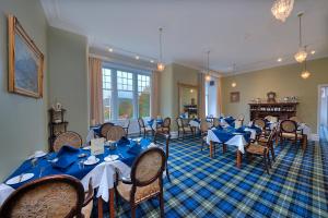 uma sala de jantar com mesas e cadeiras azuis em Falls of Lora Hotel em Oban