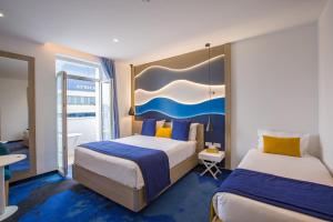 a hotel room with two beds and a desk at Hotel Carlton in Tunis +135 photos