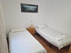 two beds in a room with a picture on the wall at Casa Dulcinea in Alborea