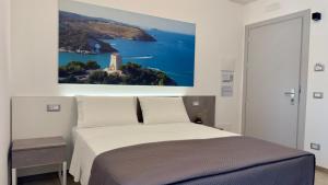a bedroom with a bed with a painting on the wall at Vesta Motel in Vieste