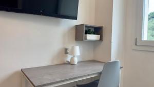 a room with a desk with a lamp and a chair at Vesta Motel in Vieste