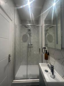 a white bathroom with a shower and a sink at Sauna Haus in Brighton & Hove +13 photos