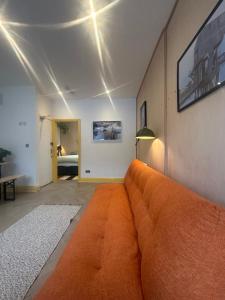 an orange couch in a living room with a bed at Sauna Haus in Brighton & Hove
