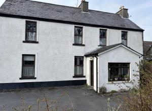 a white house with black windows at Diamond View House in Letterfrack