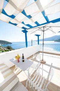 a patio with a table and chairs and an umbrella at Rania Bella Vista Studios in Poros