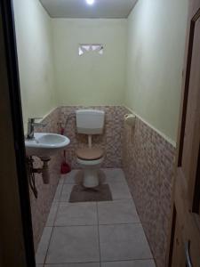 a bathroom with a toilet and a sink at Hostel Archimedes in Paramaribo