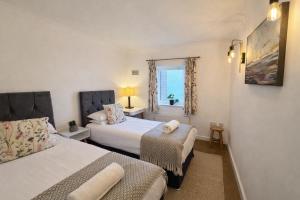 a bedroom with two beds and a window at Mango Tree Apartment - Near Leisure Park & Station in Cambridge
