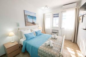 a bedroom with a bed with a blue bedspread at Rania Bella Vista Studios in Poros
