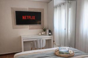 a bedroom with a bed and a desk and a television at VILLA PANGEA Habitaciones Boutique - Camino del Norte - Castro Urdiales in Castro-Urdiales