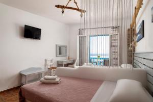 a white living room with a couch and a window at Anemos Sea View in Batsi