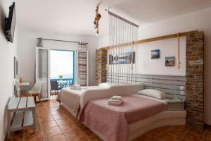 a bedroom with a large bed with a pink blanket at Anemos Sea View in Batsi