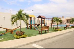 a park with a playground with benches and a pool at Newly Opened Mini Suite in Manta