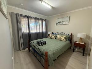 a bedroom with a bed and a window at Hideaway on King in Urangan