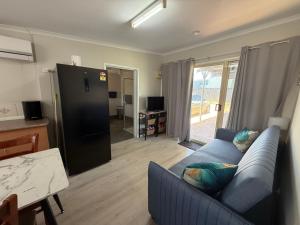 a living room with a blue couch and a kitchen at Hideaway on King in Urangan