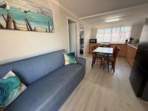 a living room with a blue couch and a table at Hideaway on King in Urangan