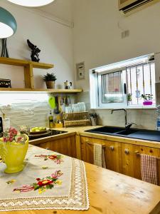 a kitchen with a table and a sink and a counter at La Corte di Noto in Noto +18 photos