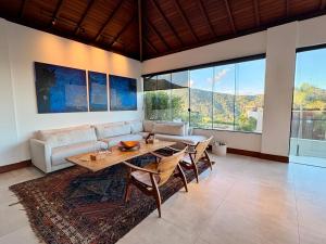a living room with a couch and a table at Casa 05 Monte Boa Vista - Casa de Luxo na Serra com Sauna e 4 Suítes in Teresópolis