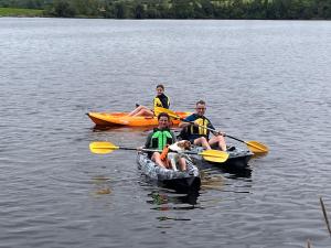 three people and a dog in kayaks on a lake at Linden Lodge at Lough Sillan House - Dog-friendly - Adults only in Shercock