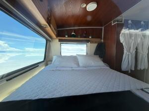 a bed in the middle of a room with a window at Camper Elegance Uyuni - All Inclusive in Carpas