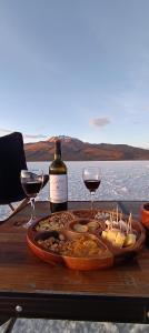 a table with a plate of food and two glasses of wine at Camper Elegance Uyuni - All Inclusive in Carpas