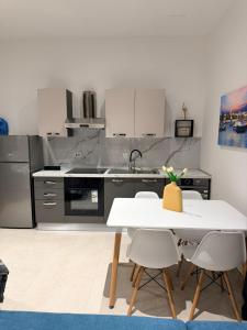 a kitchen with stainless steel appliances and a white table at The White Balcony in Il-Gżira