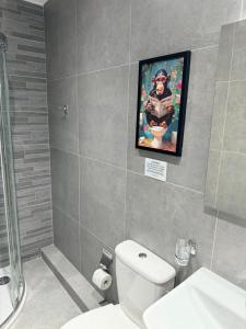 a bathroom with a toilet and a picture on the wall at The White Balcony in Il-Gżira