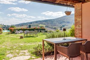 a table and chairs on a patio with a view at Villa Del Sole in San Gimignano