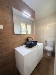 a bathroom with a black sink and a toilet at Central Suites Silgar Sanxenxo in Sanxenxo