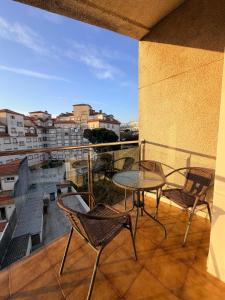 a balcony with a table and chairs and a view at Central Suites Silgar Sanxenxo in Sanxenxo